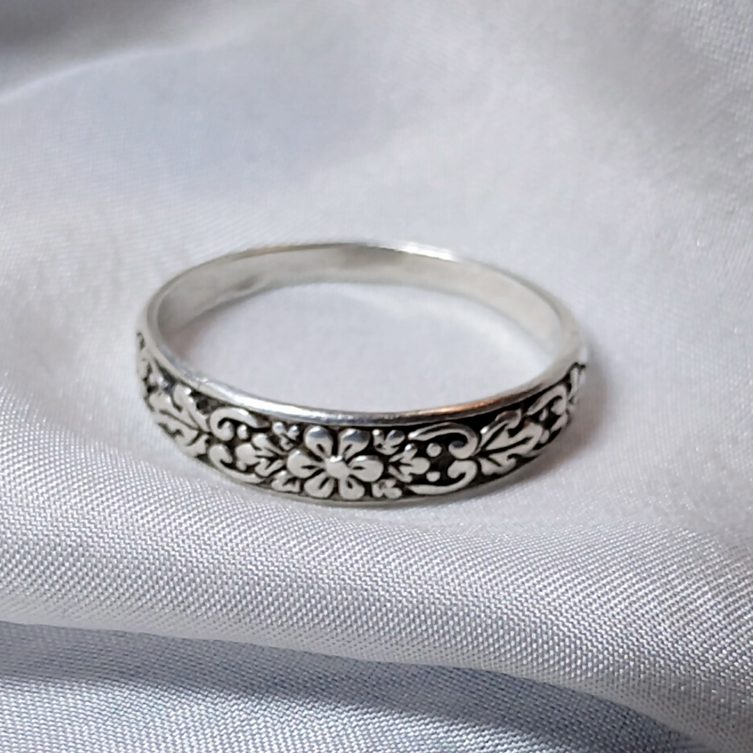 Antique sterling silver Art Nouveau ring with intricate floral and vine motifs in a classic, handcrafted design.