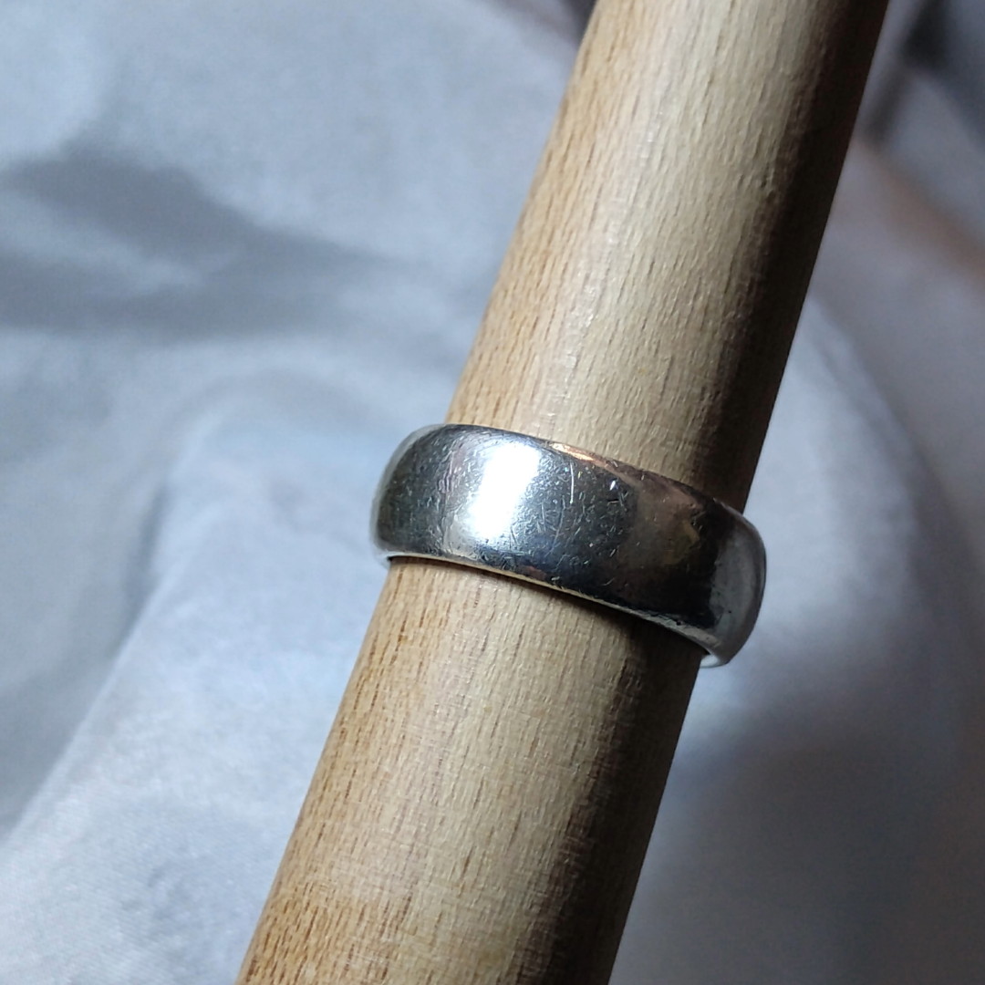 Wide band sterling silver ring with a smooth, minimalist finish.