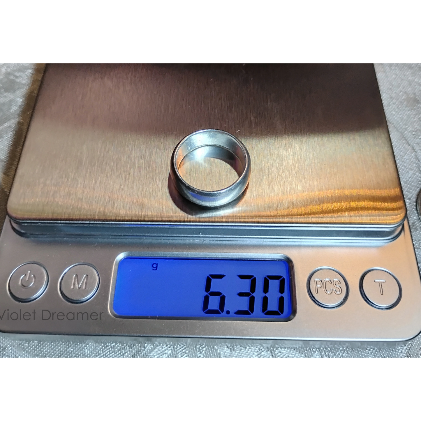 A vintage, wide band silver ring, size 6, sitting on a digital scale, with a reading of 6.3g from Violet Dreamer.