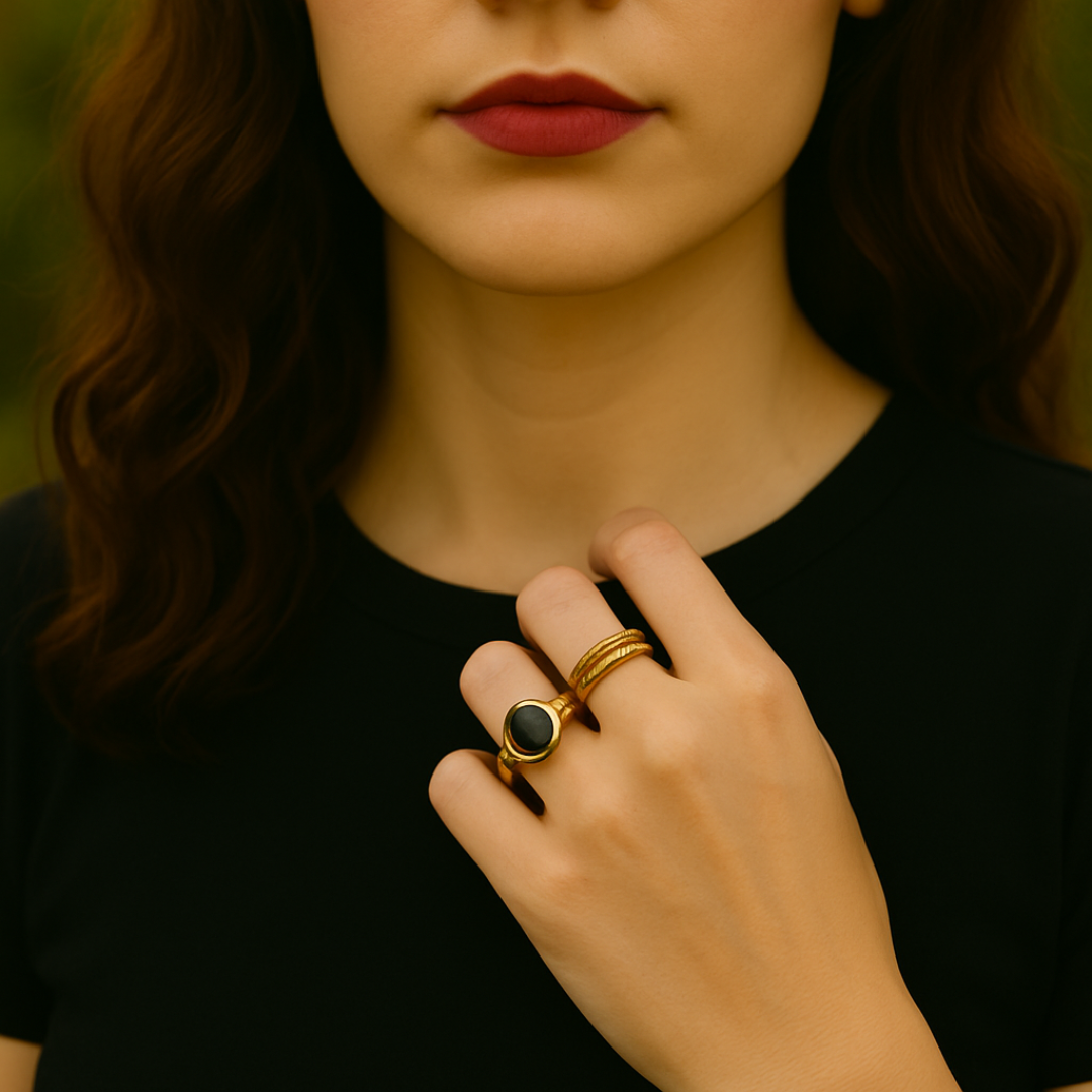 A woman in a field at sunset wearing two gold rings on her left had from Violet Dreamer