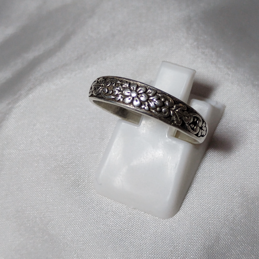 Antique sterling silver Art Nouveau ring with intricate floral and vine motifs in a classic, handcrafted design.