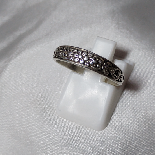 Antique sterling silver Art Nouveau ring with intricate floral and vine motifs in a classic, handcrafted design.