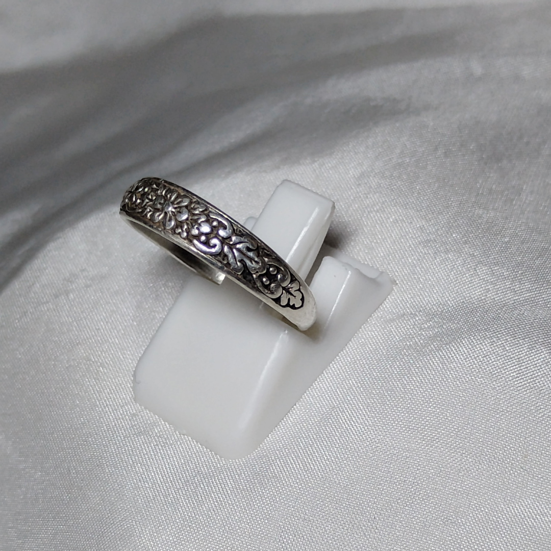 Antique sterling silver Art Nouveau ring with intricate floral and vine motifs in a classic, handcrafted design.