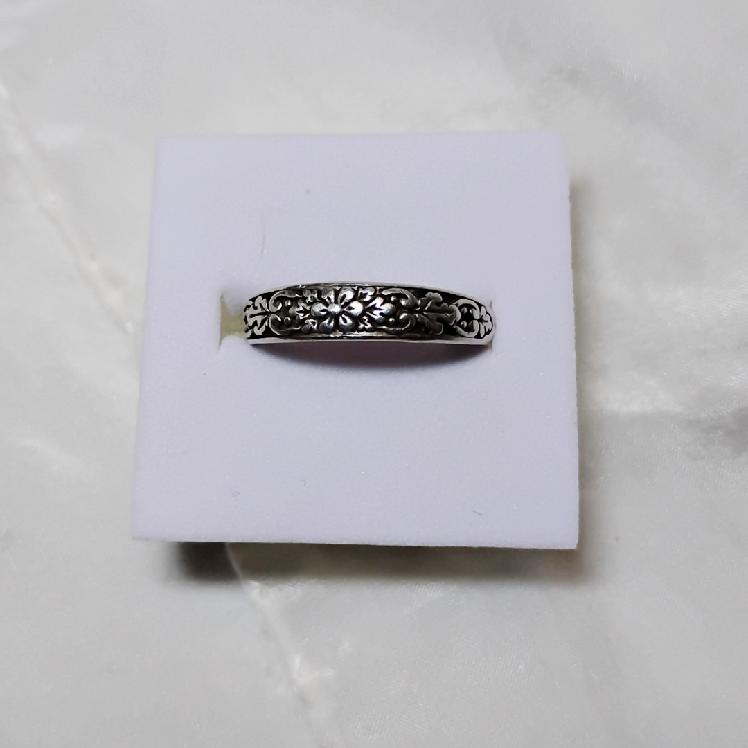 Antique sterling silver Art Nouveau ring with intricate floral and vine motifs in a classic, handcrafted design.
