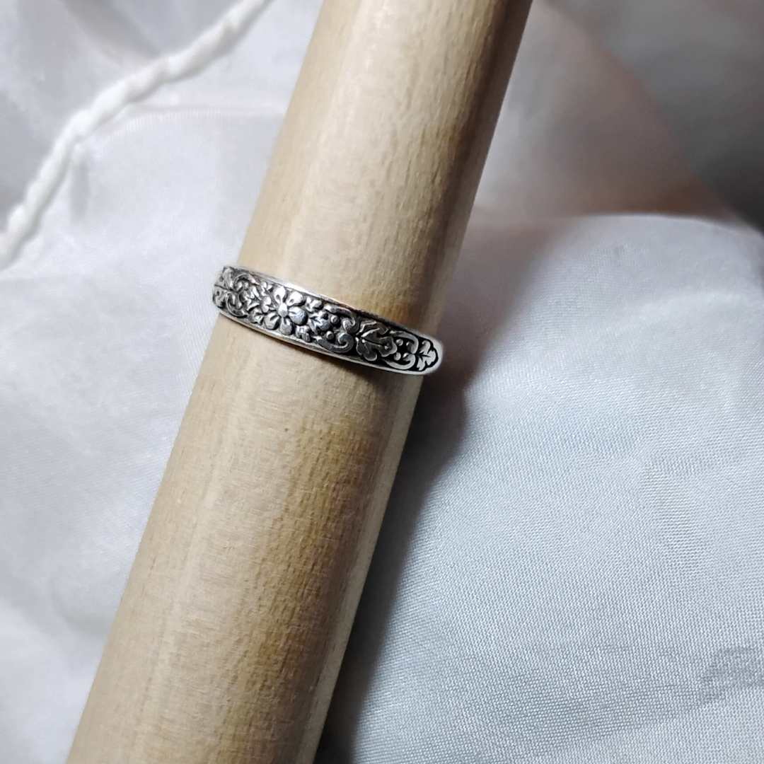 Antique sterling silver Art Nouveau ring with intricate floral and vine motifs in a classic, handcrafted design. 