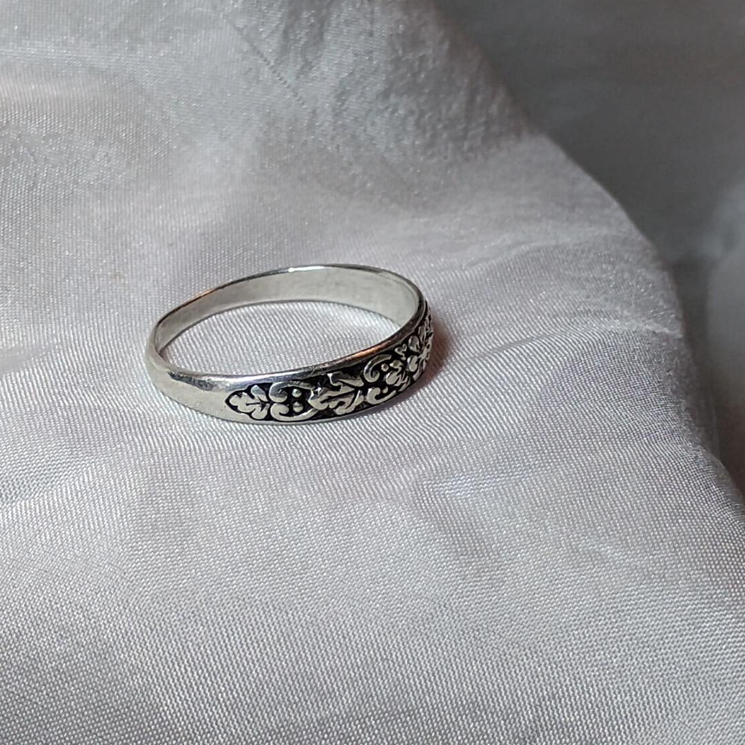 Antique sterling silver Art Nouveau ring with intricate floral and vine motifs in a classic, handcrafted design.