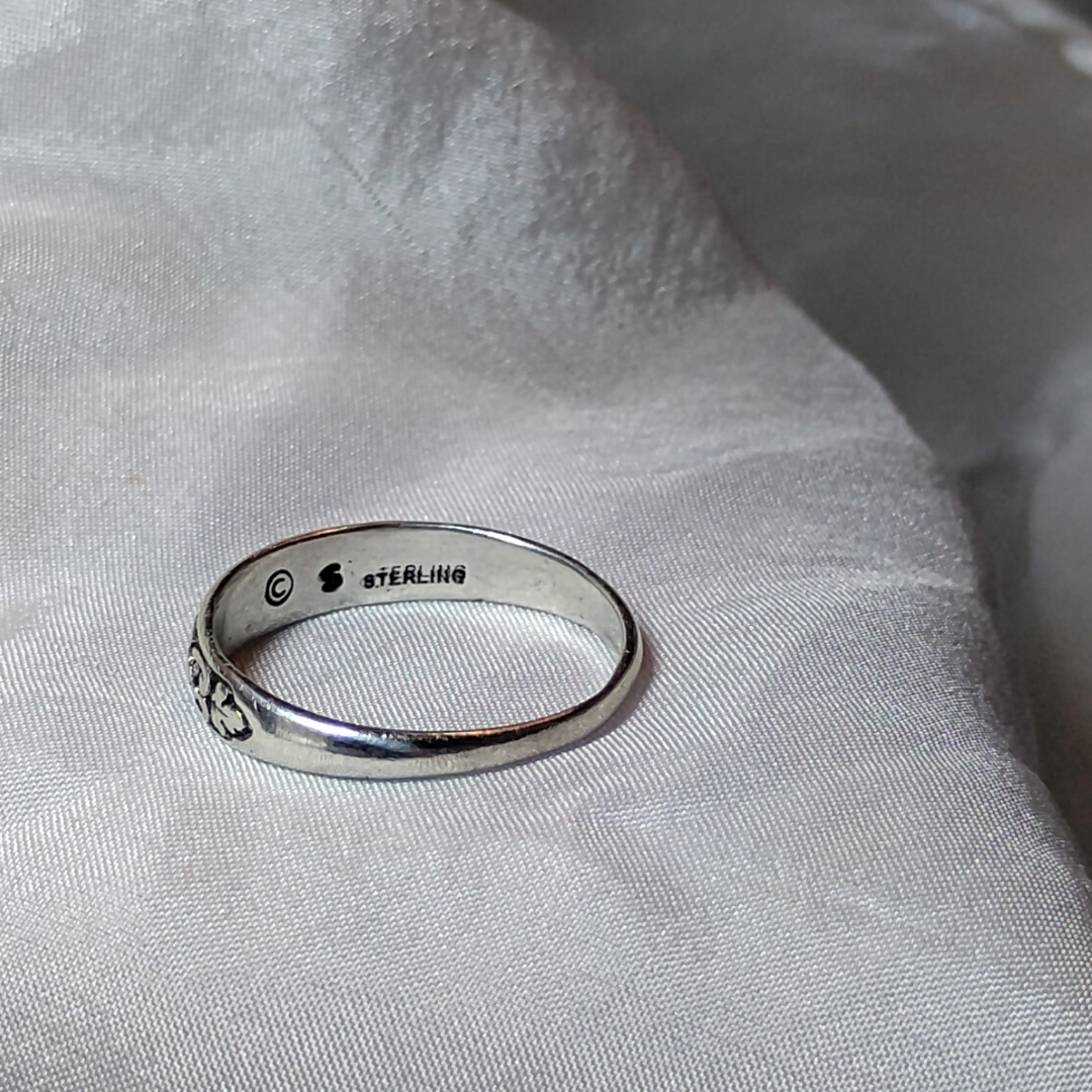 Antique sterling silver Art Nouveau ring with intricate floral and vine motifs in a classic, handcrafted design.