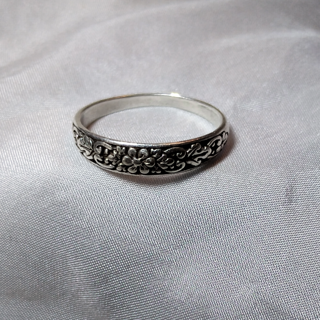 Antique sterling silver Art Nouveau ring with intricate floral and vine motifs in a classic, handcrafted design.